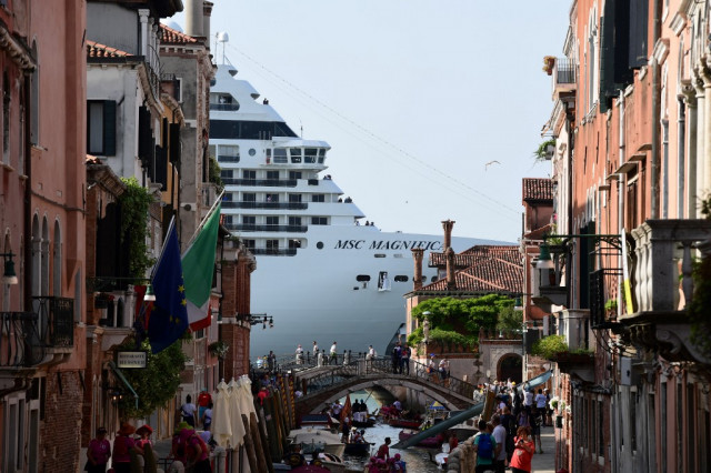 A cruise ship overshadows a Venetian canal
